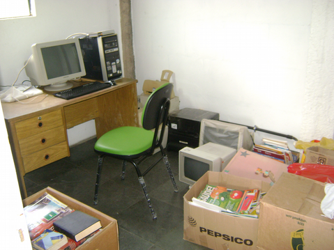 Sala com mesa e computador para o controle do acervo e empréstimos.